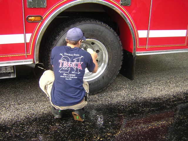 Firefighter Bob Fraser polishing the rims on Engine 1.